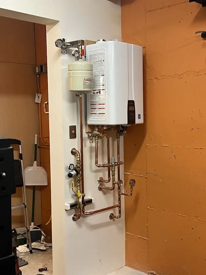 Plumbing technician inspecting water heater connections in Westbrook